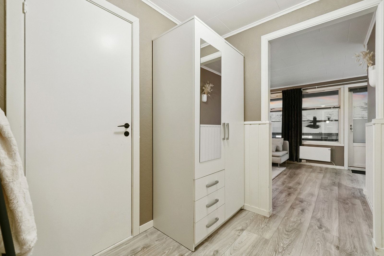 En romslig mellomgang knytter sammen alle leilighetens rom. Her det er plass for garderobeløsning. Galleribilde