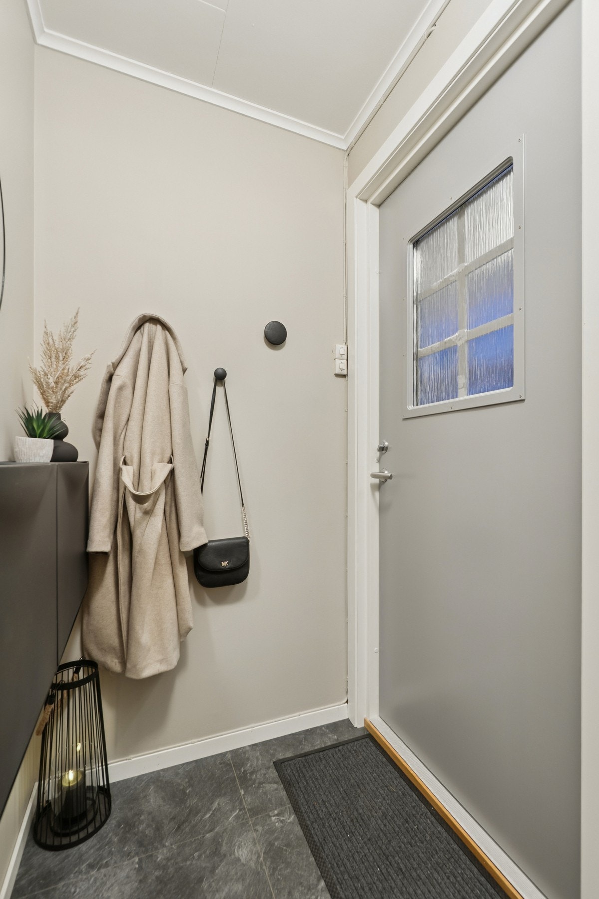 I bakkant av blokken finner du boligens inngangsparti, hvor det er en entré med plass til enkle garderobeløsninger. Galleribilde