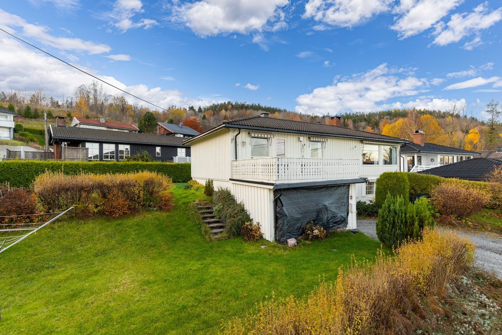Eiendommen har en pent opparbeidet hage over flere plan med gressplen, hekk og busker. Galleribilde