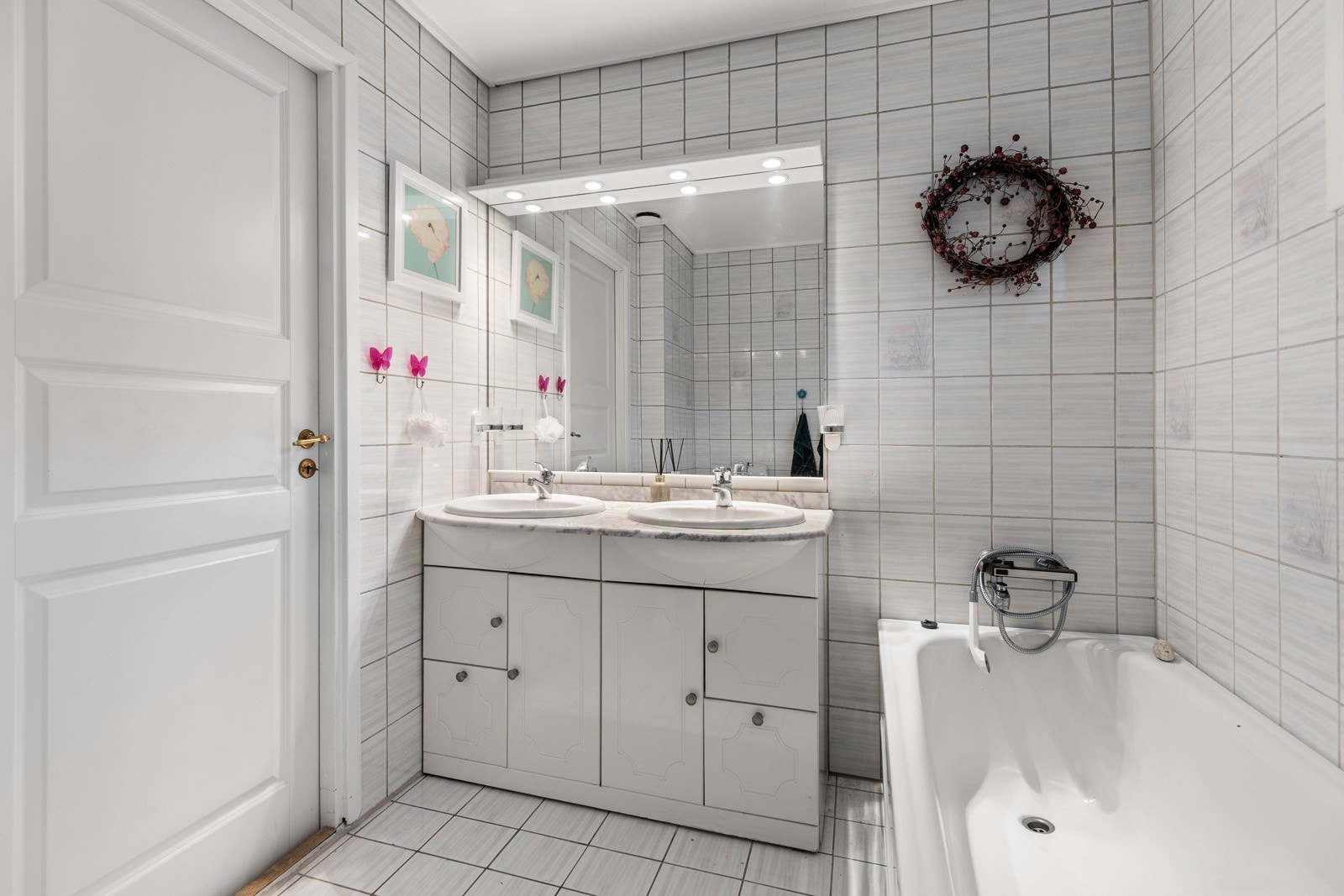 Det er innredet med dobbeltservant med underskap, stort speil med belysning, toalett og badekar. Galleribilde