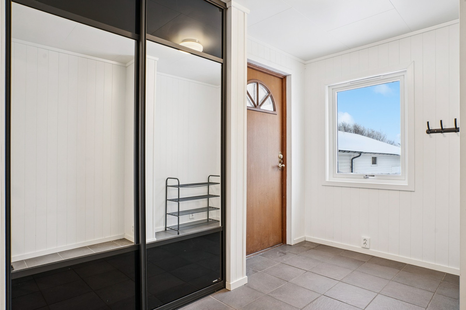 Velkommen inn i flislagt entré. Her finner du en praktisk skyvedørsgarderobe. Galleribilde