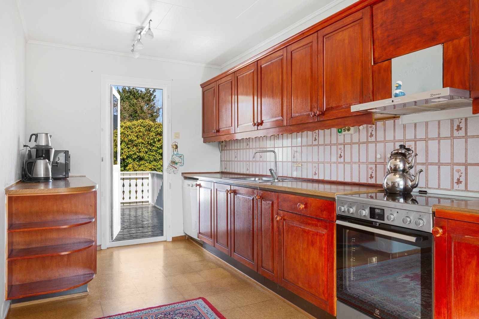 Kjøkkeninnredningen er malt profilert- legg merke til den praktiske utgangen fra kjøkkenet til terrassen og hagen Galleribilde