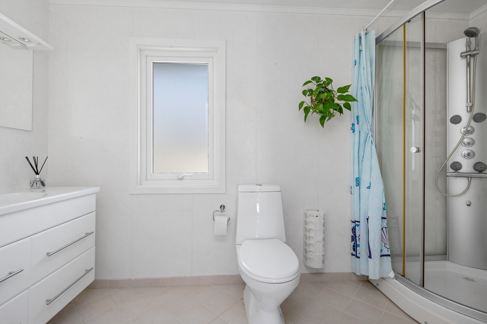 Badet har fliser på gulv med varmekabel og tapet på vegg Galleribilde