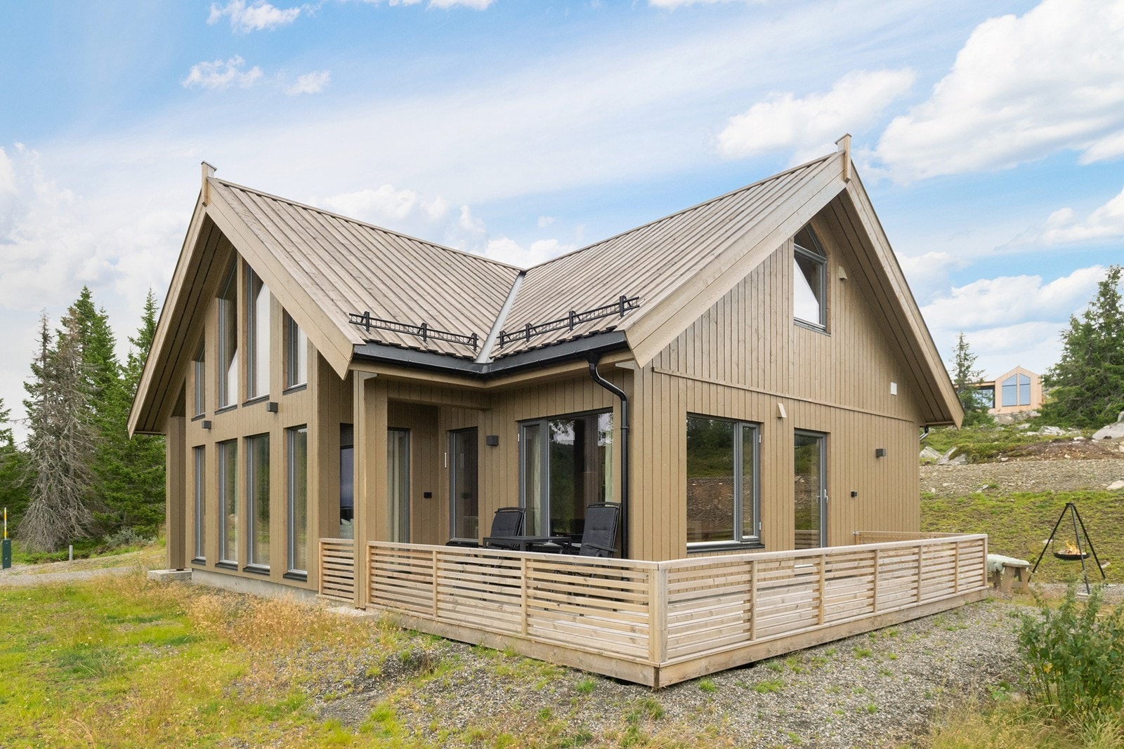 Hytten er i en gjennomført og moderne stil med rekkverk i spiler og store vindusflater. Foto: Exponering Svein Michaelsen Galleribilde