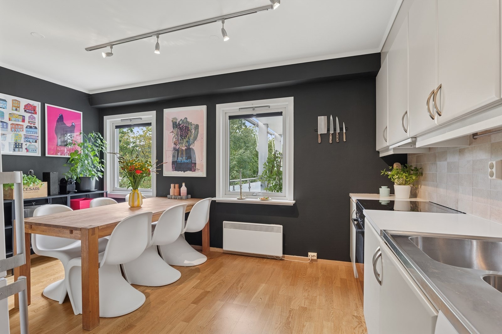 Det er plass til stort spisebord på kjøkken - og rommets spennende fargevalg gjør det til leilighetens hjerte Galleribilde