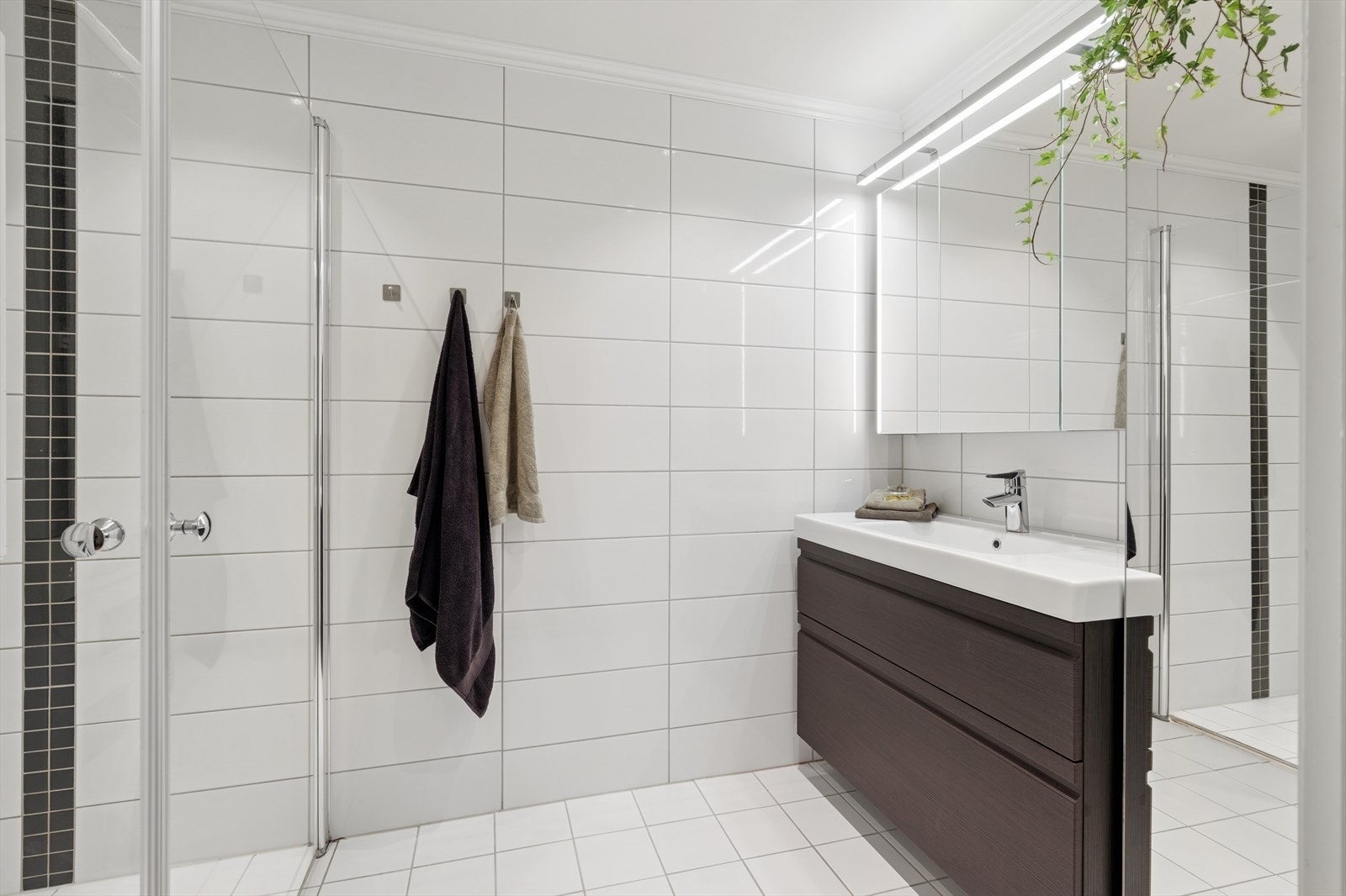 Pent flislagt badeværelse fra 2015 med servant, høyskap og dusjhjørne Galleribilde