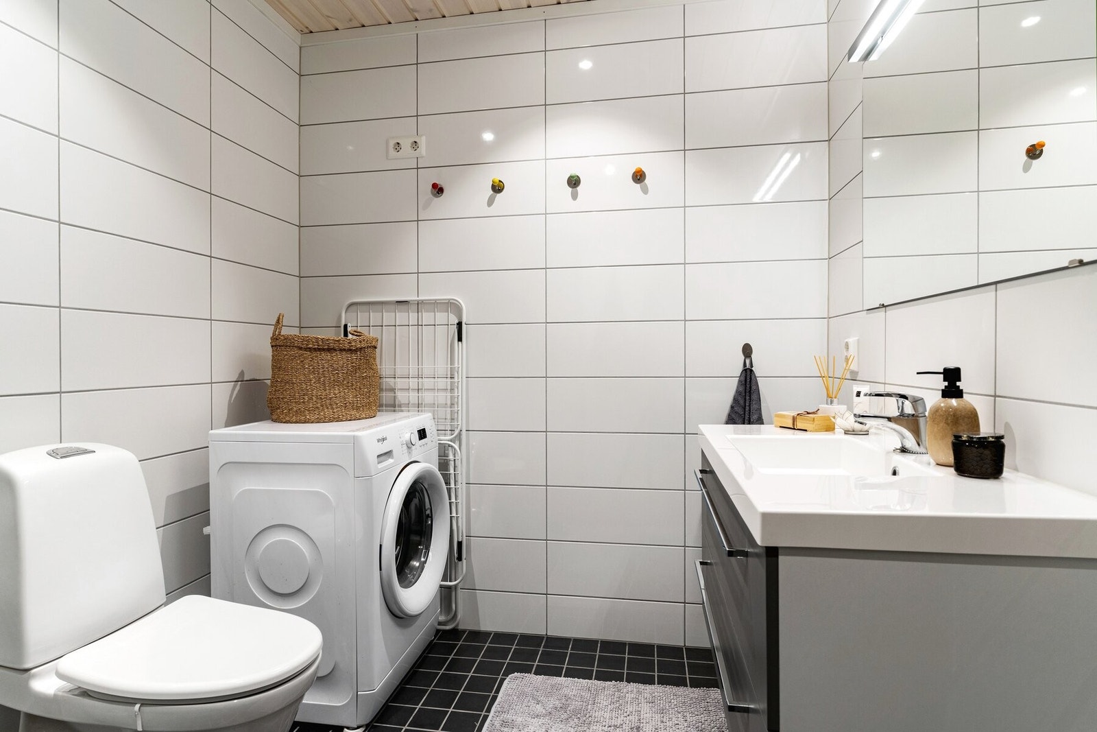 Flislagt bad med servantskap, toalett og dusjhjørne. Opplegg for vaskemaskin. Galleribilde