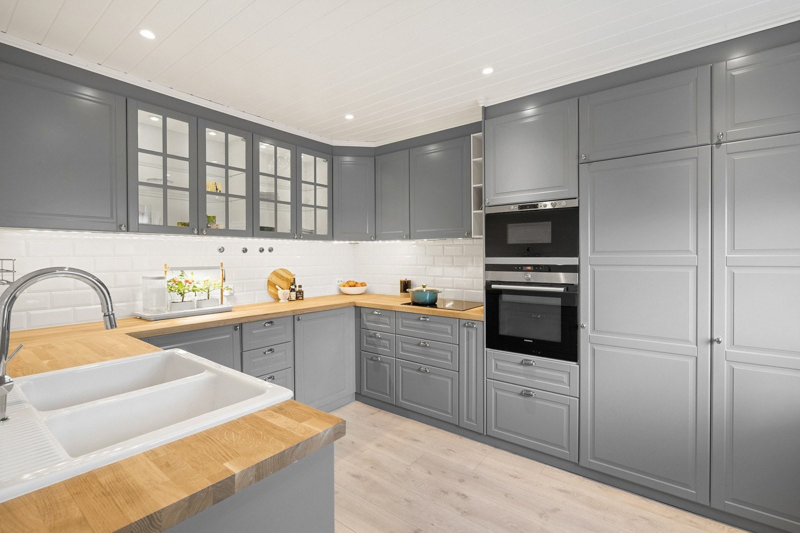 Et flott kjøkken med takhøy innredning, integrerte hvitevarer og rikelig med oppbevaringsplass. Galleribilde