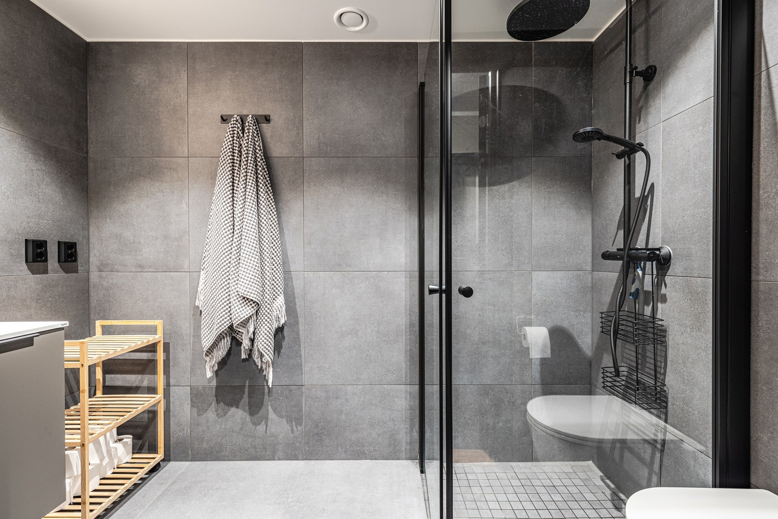 Lekkert baderom med 60 x 60 fliser i tidsriktig gråtone med passende sort garnityr. Galleribilde