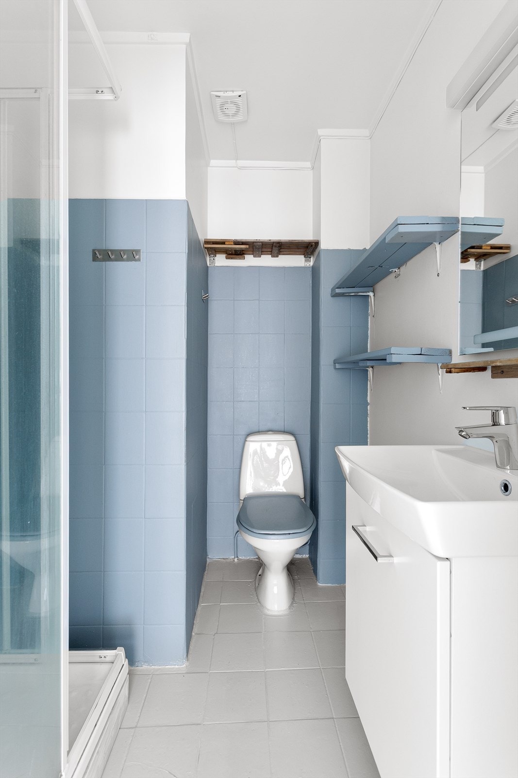 Baderom innredet med toalett, servant nedfelt i innredning og dusjkabinett. Galleribilde