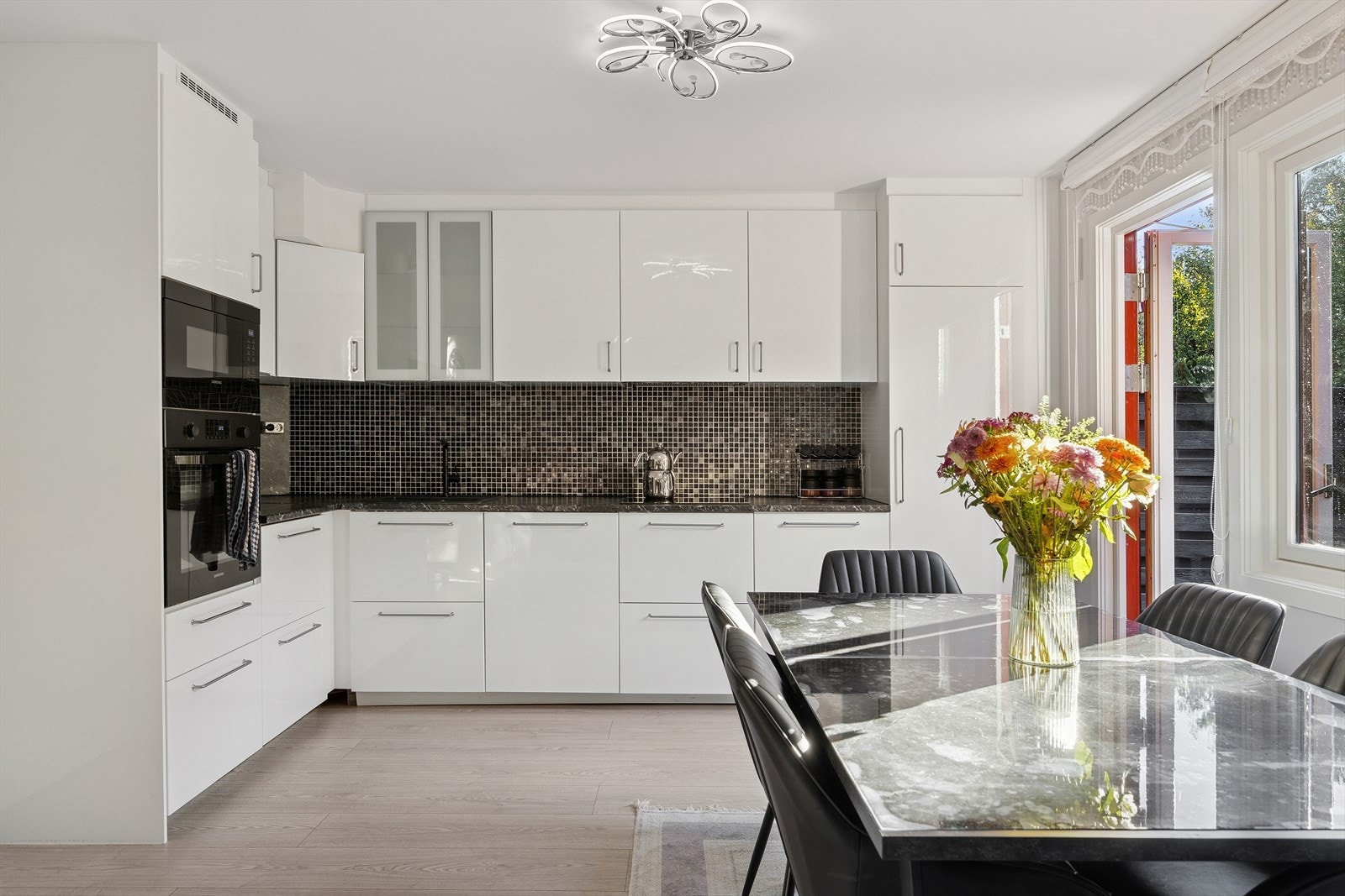 Åpen løsning som gir god flyt mellom kjøkken og stue skaper et sosialt oppholdsrom. Galleribilde