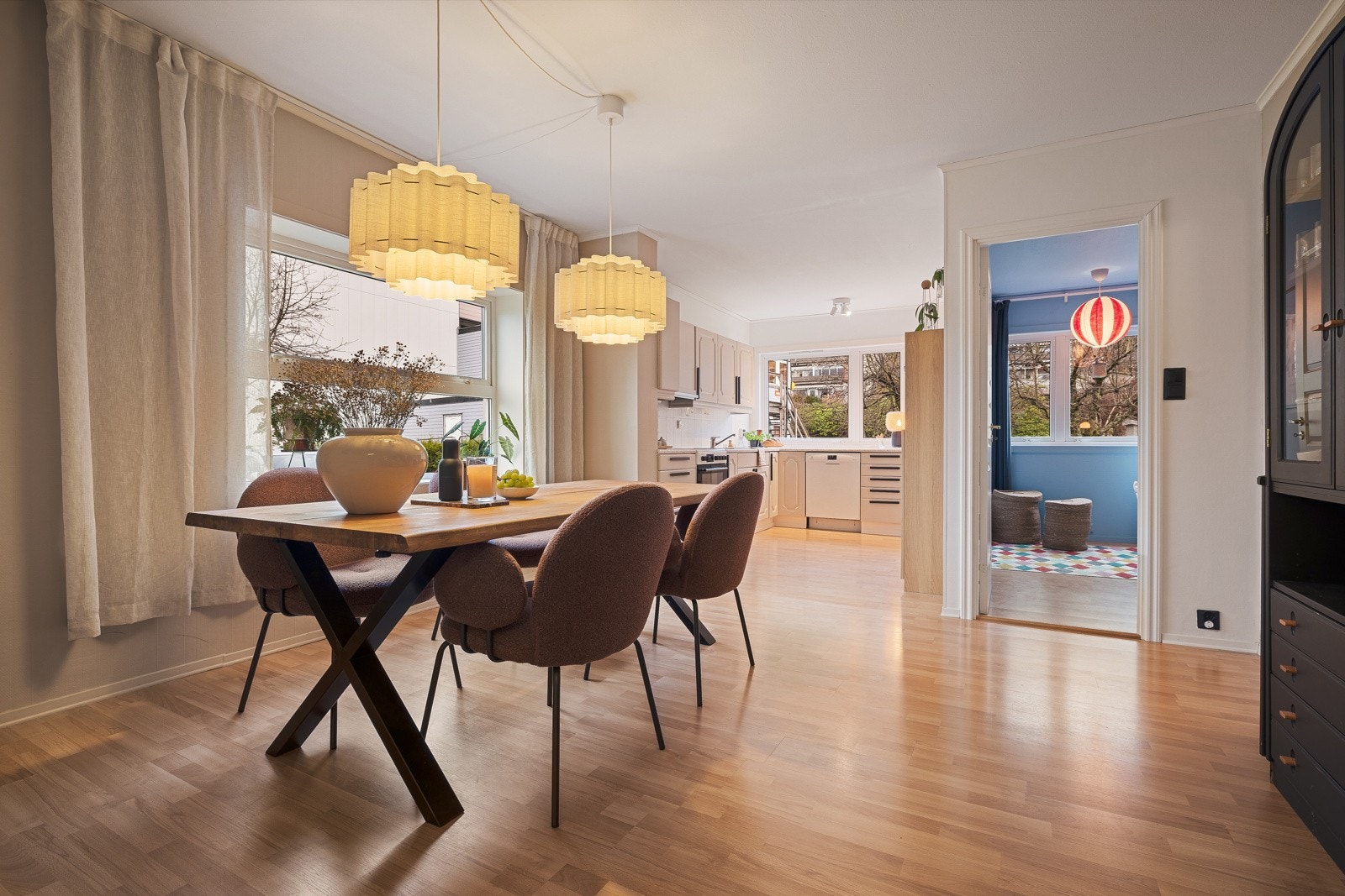 Romslig kjøkken på 24,1 m² med laminatgulv, malte flater og malt tapet på veggene samt malte slette flater i tak. Galleribilde