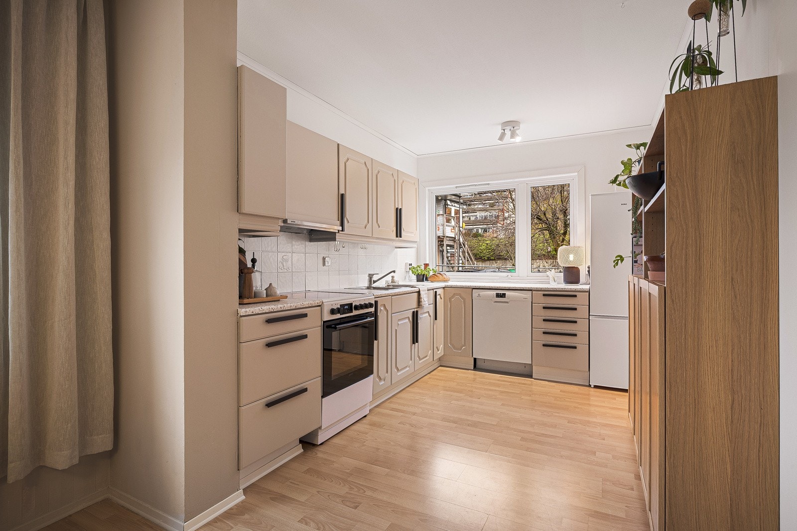 Kjøkkeninnredningen har profilerte fronter og benkeplate i laminat med nedfelt stålvask. Av integrerte hvitevarer er ventilator installert. Galleribilde