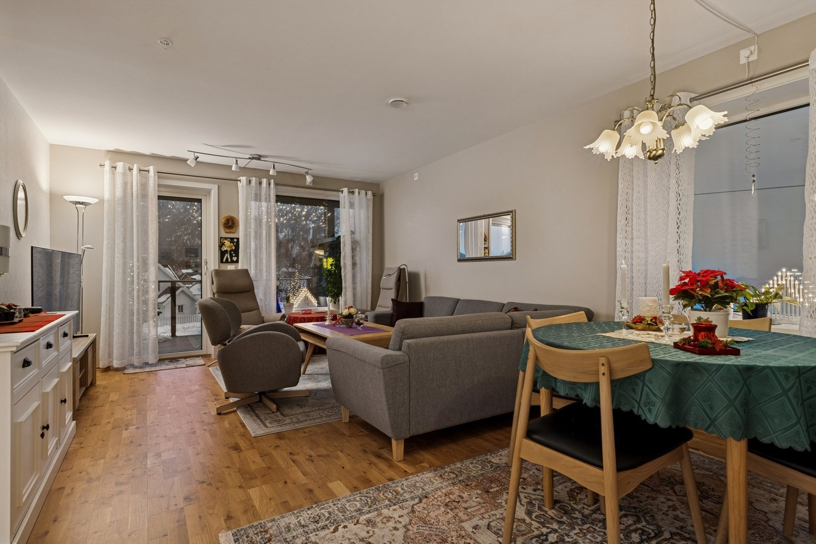 Spiseplass i stuen med utsyn mot terrassen, omgitt av store vindusflater. Galleribilde