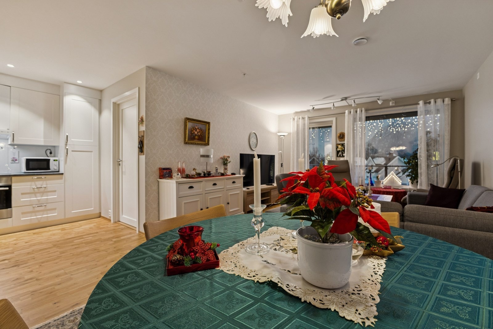 Åpen stue- og kjøkkenløsning med parkettgulv og integrerte hvitevarer. Galleribilde