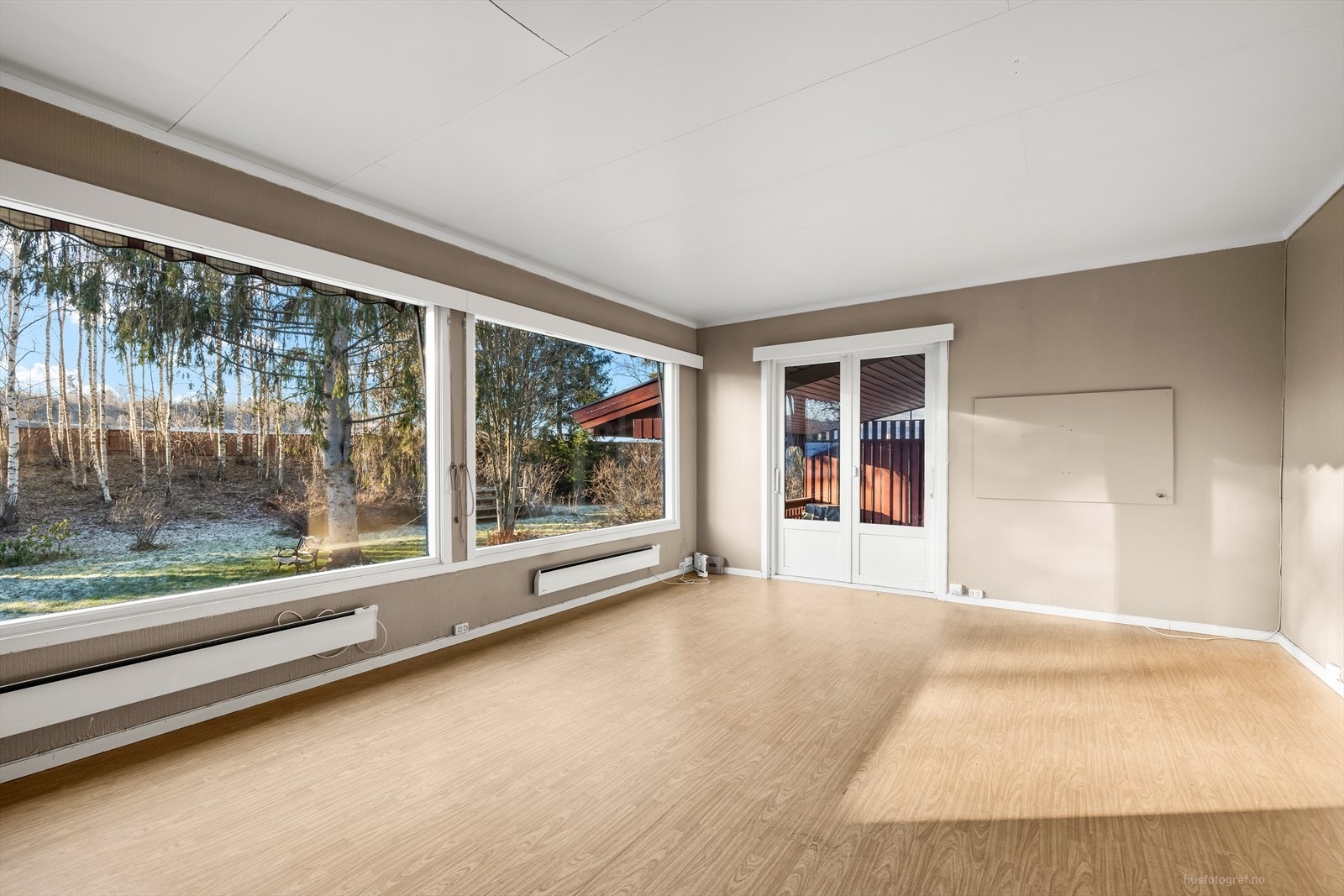 Boligen har stor vinduer ut mot den skjermede hagen. Galleribilde