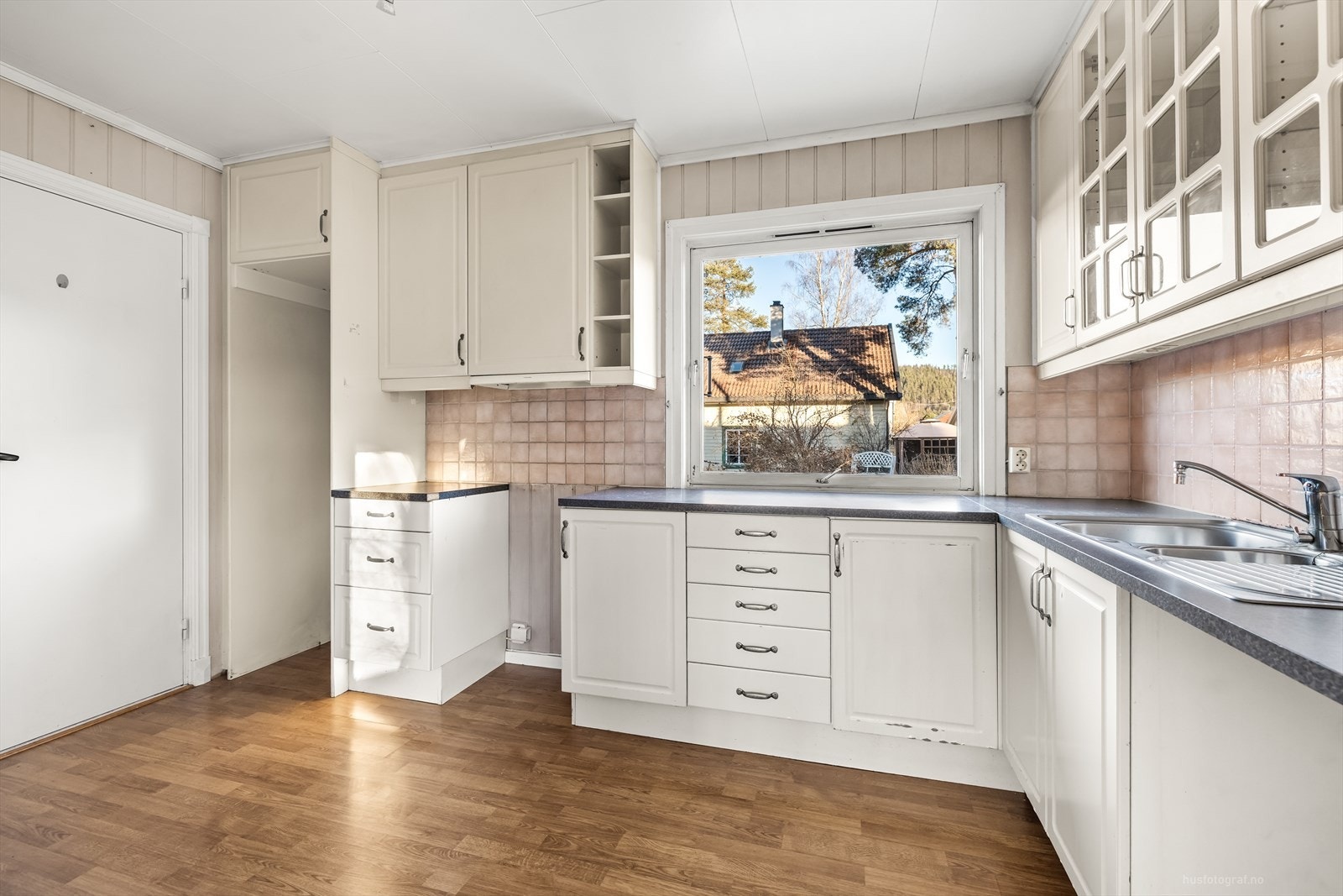 Kjøkken inneholder behandlet innredning med profilerte fronter. Benkeplate består av laminat. Galleribilde