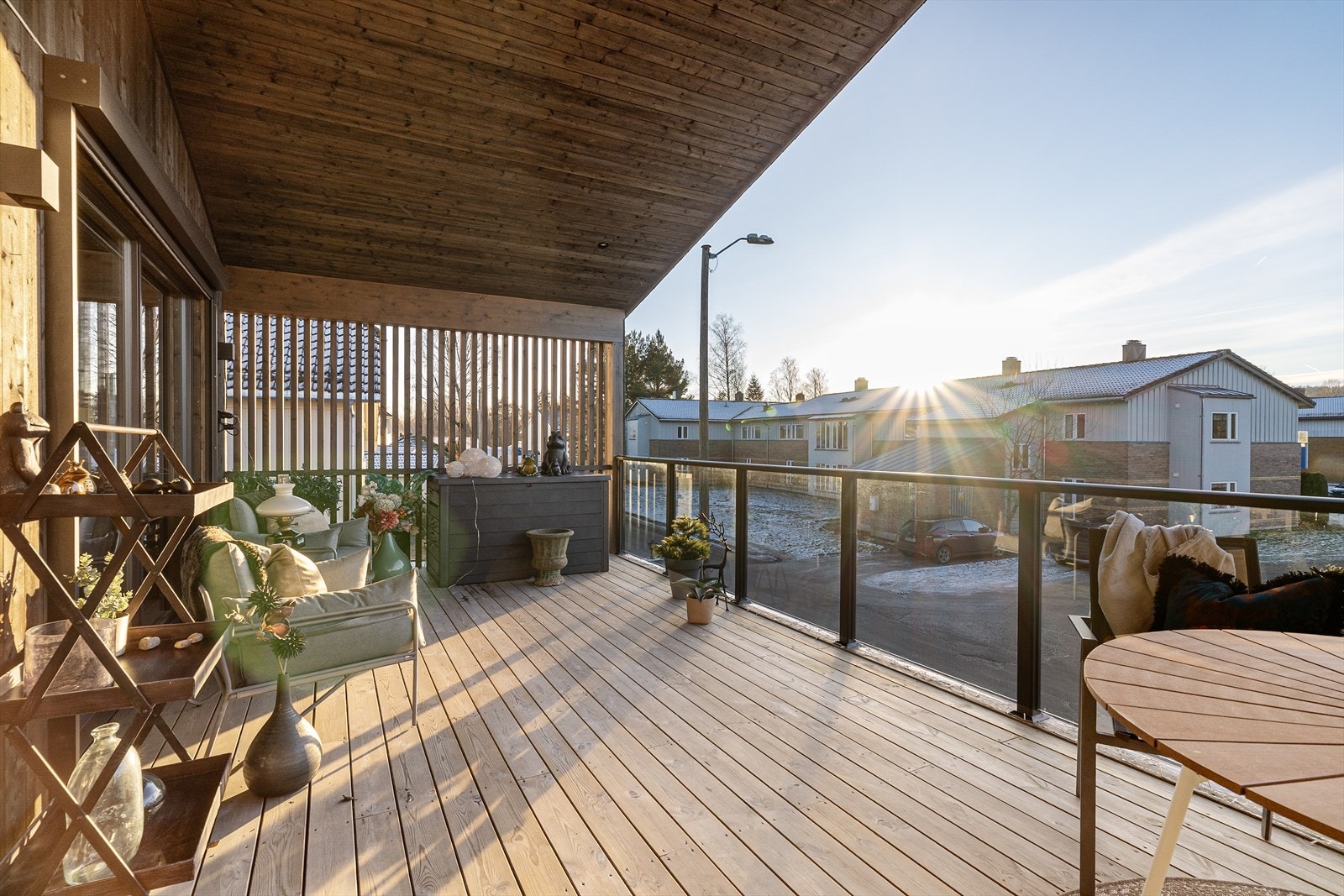 Terrassen er overbygget og fremstår lun og god med spiler på sidene og glassrekkverk i front. Galleribilde