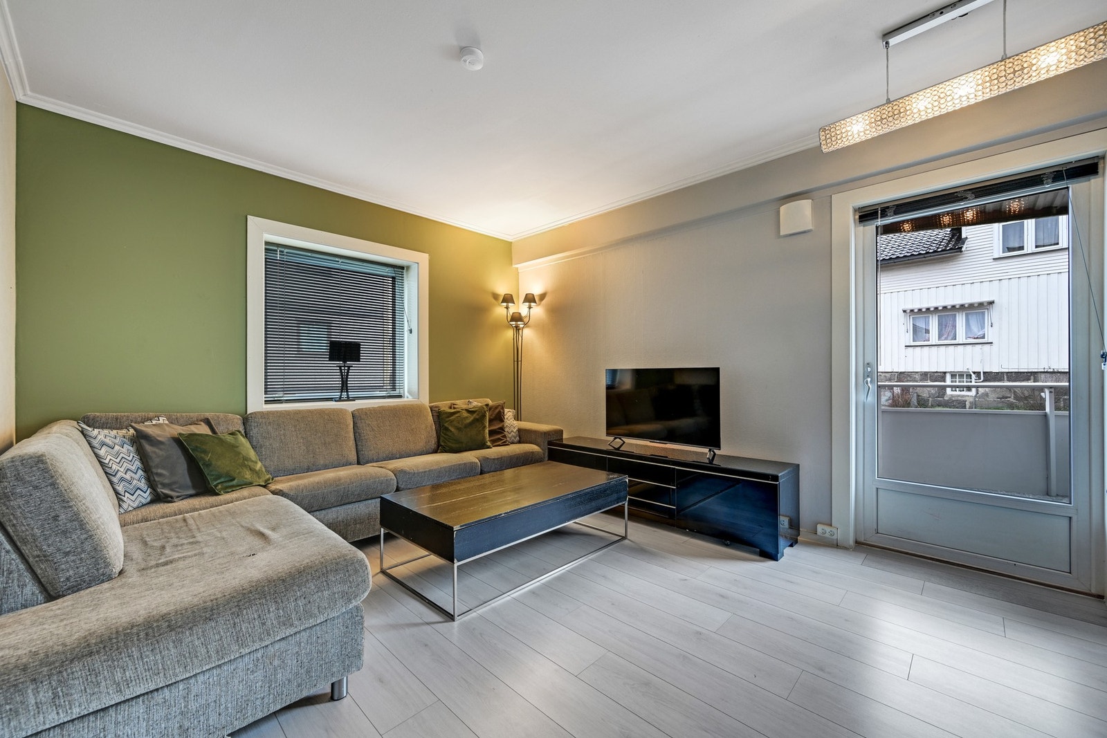 Romslig stue med fine farger og store vindusflater Galleribilde