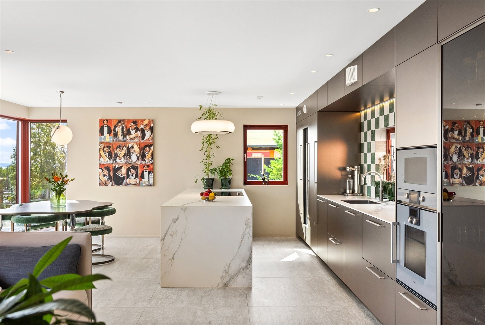 Kjøkkenet har Poliform-innredning i bronseutførelse med glatte fronter, som gir et stilrent og moderne uttrykk. Benkeplaten er laget av heltilpassede keramiske plater, som kombinerer estetikk med funksjonalitet. Galleribilde