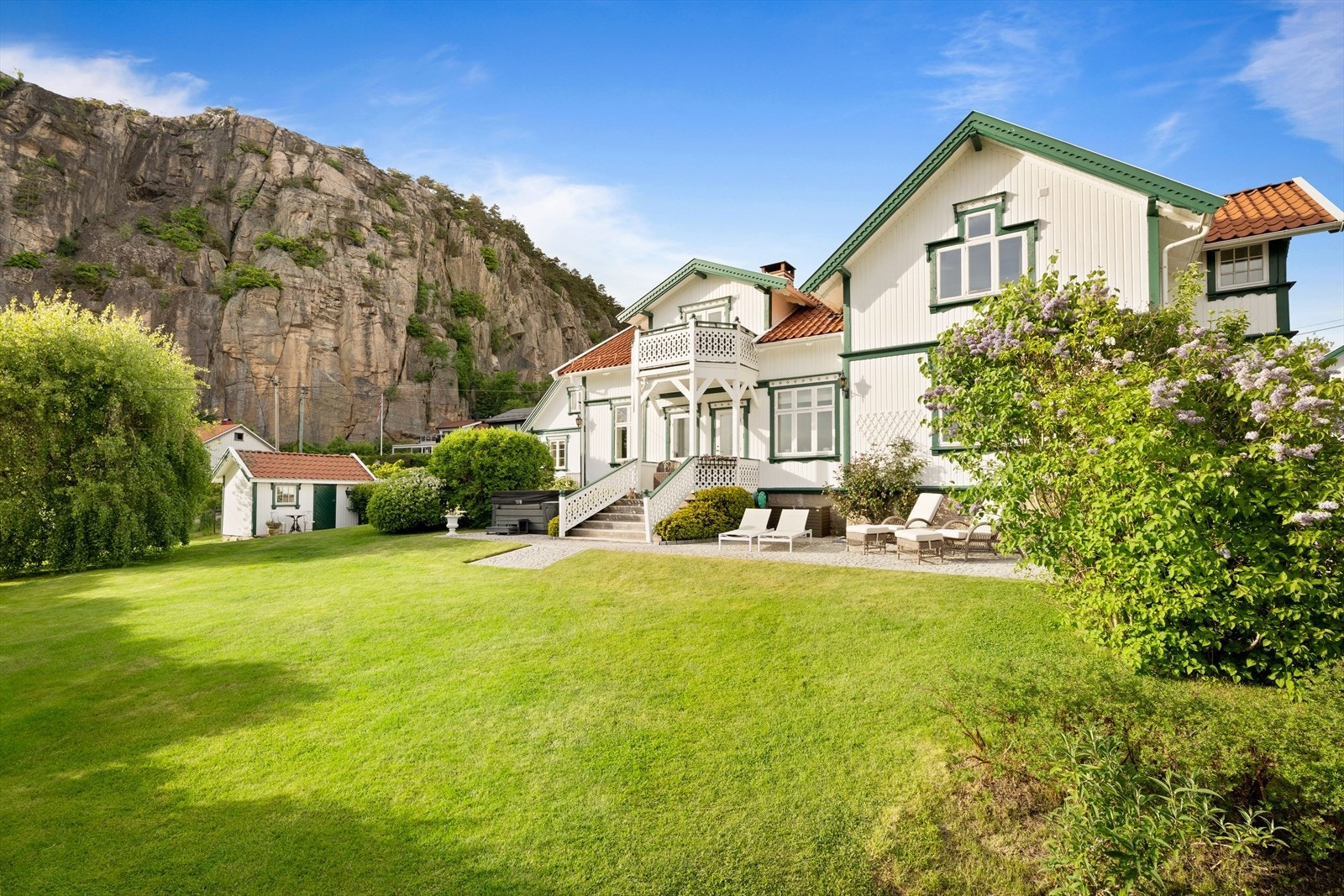 Pent opparbeidet hage med plen, busker og beplantning - skrånende mot sjøen med "tøffelavstand" til badestrand. Galleribilde