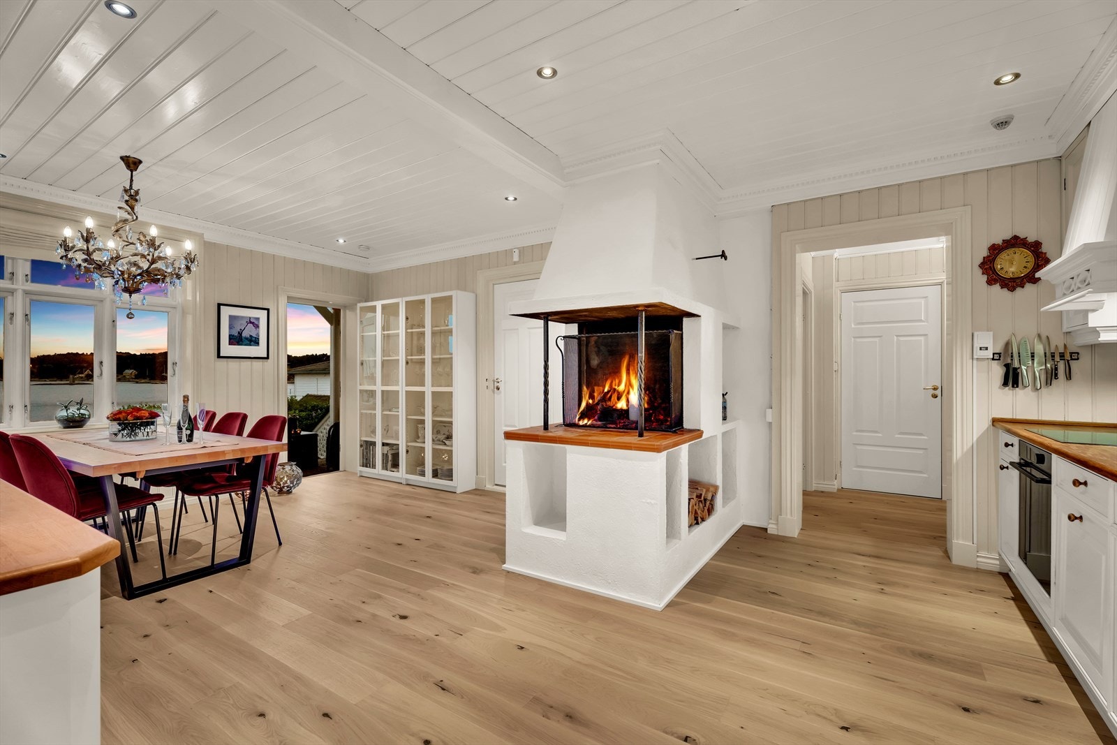 Åpen peis som binder kjøkken og spisestue sammen - et varmt og stemningsfullt midtpunkt i boligen. Galleribilde