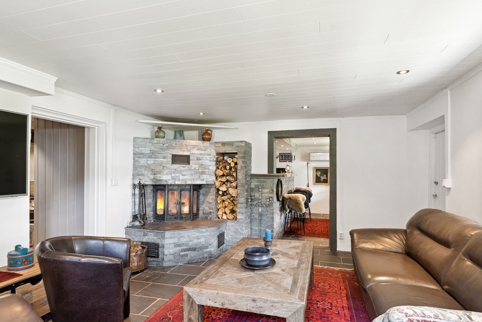 Stue kjeller. En svært hyggelig peisestue som går i ett med den flotte baren som er meget godt utstyrt. Galleribilde