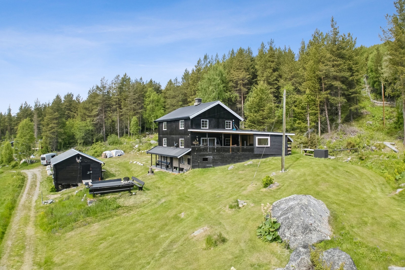 Drone bilde, med to praktisk overbyggende sitteplasser og en stor veranda. Galleribilde