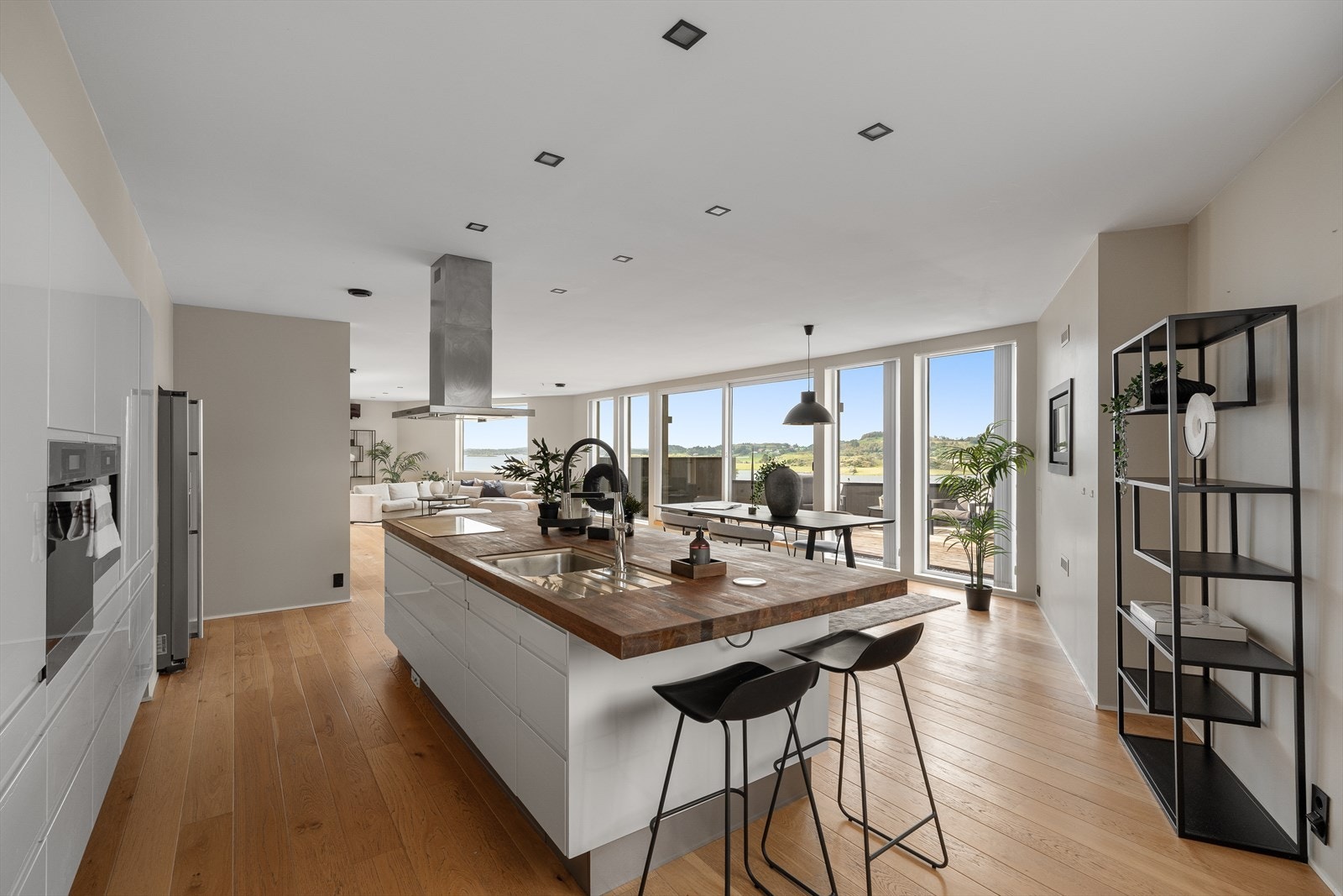 Elegant kjøkken med rene linjer, kjøkkenøy og integrerte hvitevarer - et naturlig samlingspunkt i boligen. Galleribilde