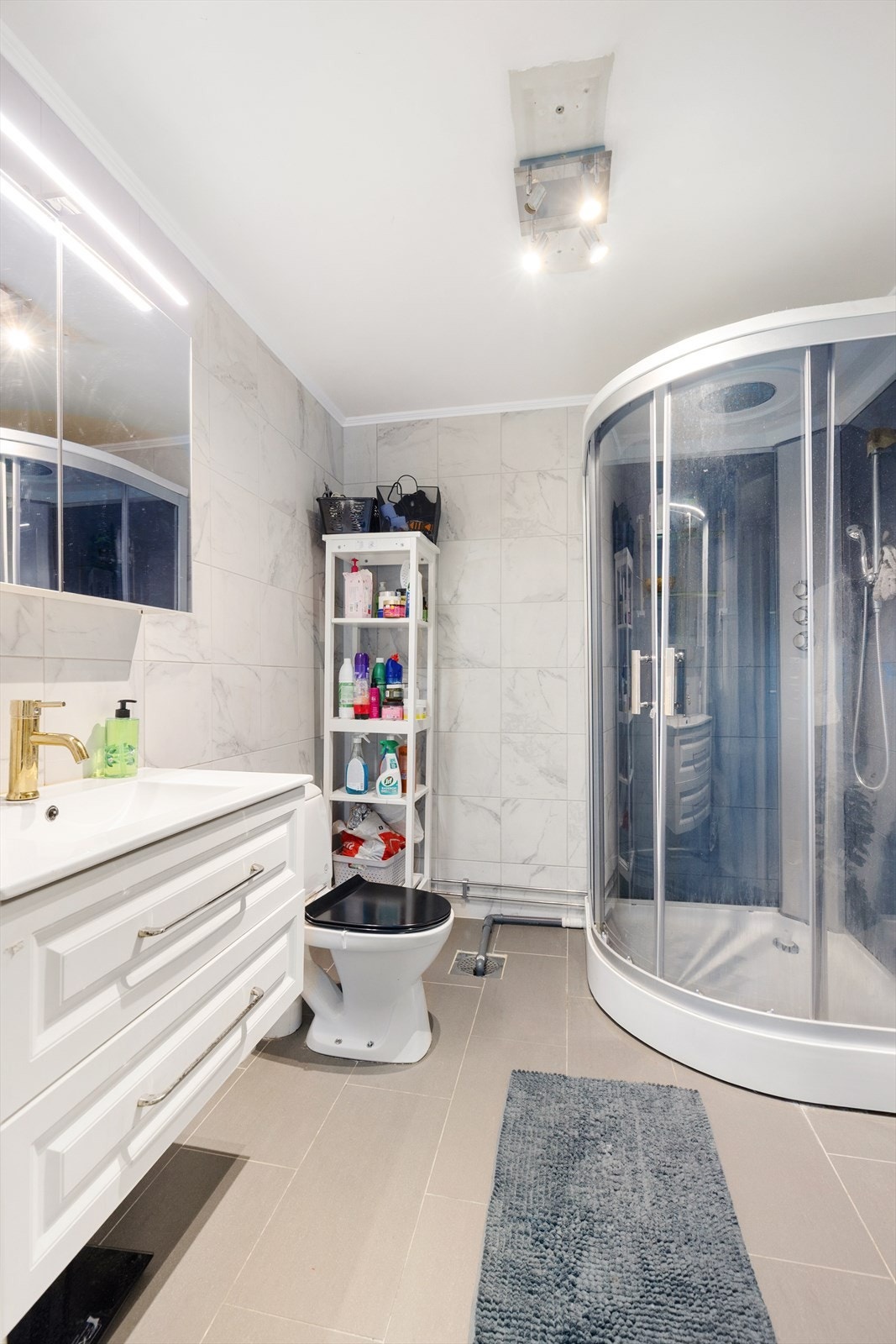 Badet er også innredet med dusjkabinett samt et eldre toalett.
Badet er pusset opp som egeninnsats, med fremvist video av membran bak flis. For øvrig ingen dokumentasjon. Galleribilde