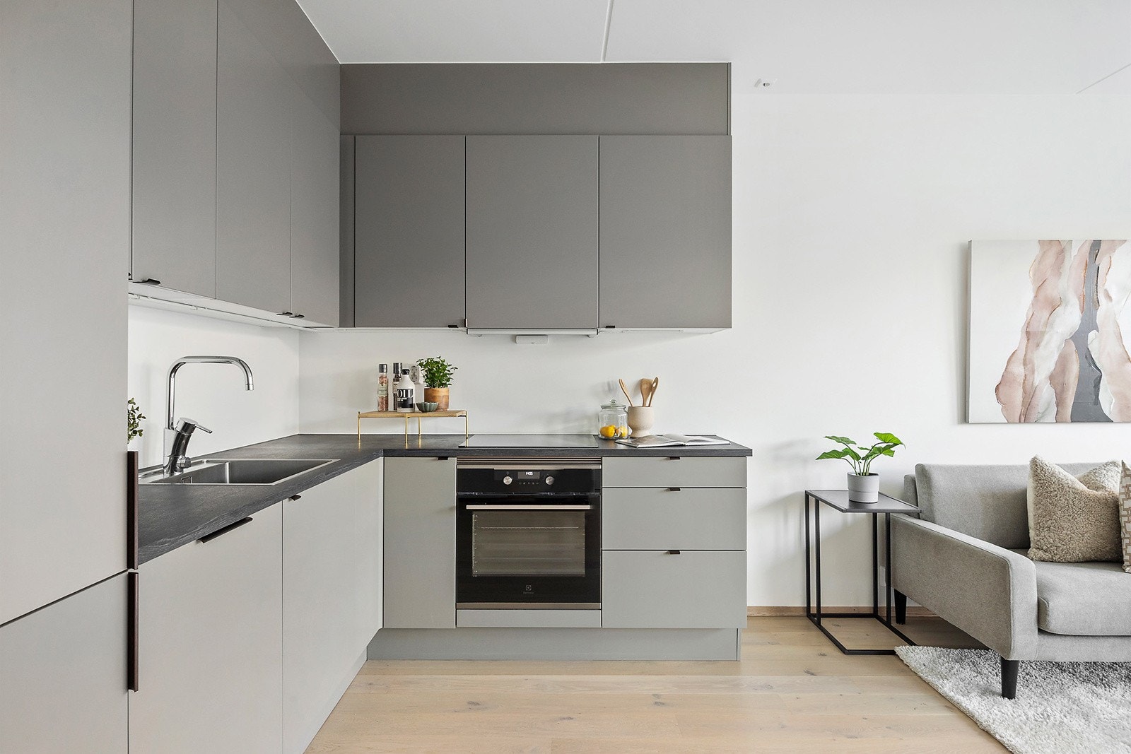 Stilrent HTH-kjøkken med slette fronter, laminatbenkeplate, oppvaskkum, ventilator og komfyrvakt. Galleribilde