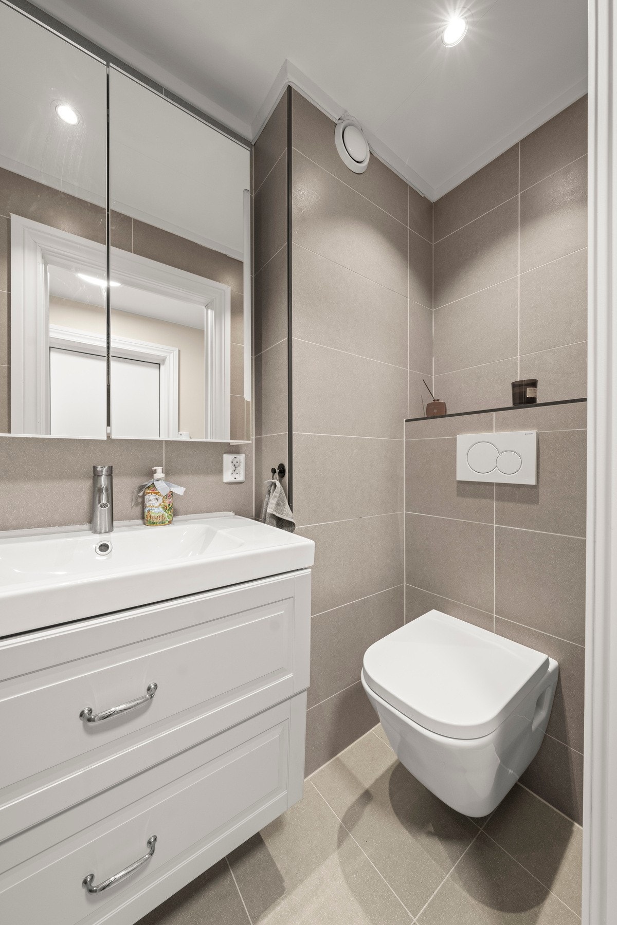 Funksjonelt bad utstyrt med dusjhjørne, vegghengt toalett og servant. Galleribilde