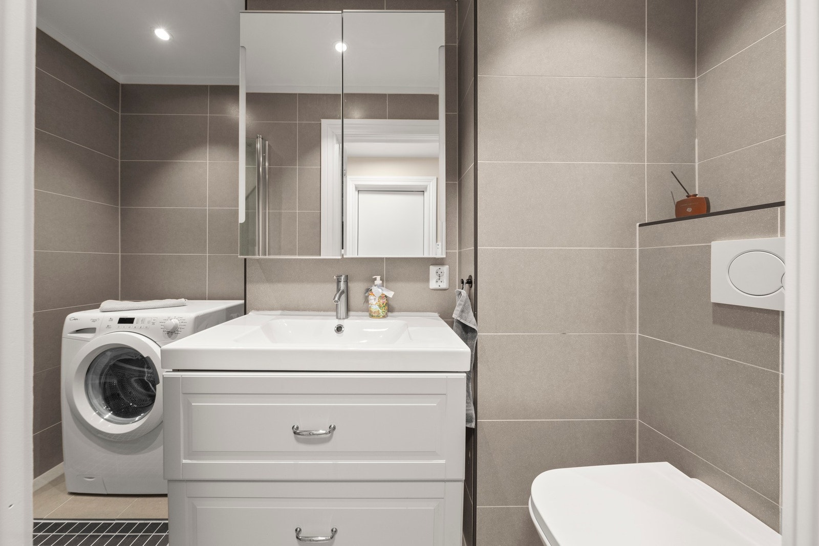 Fliselagt bad med opplegg for vaskemaskin. Galleribilde