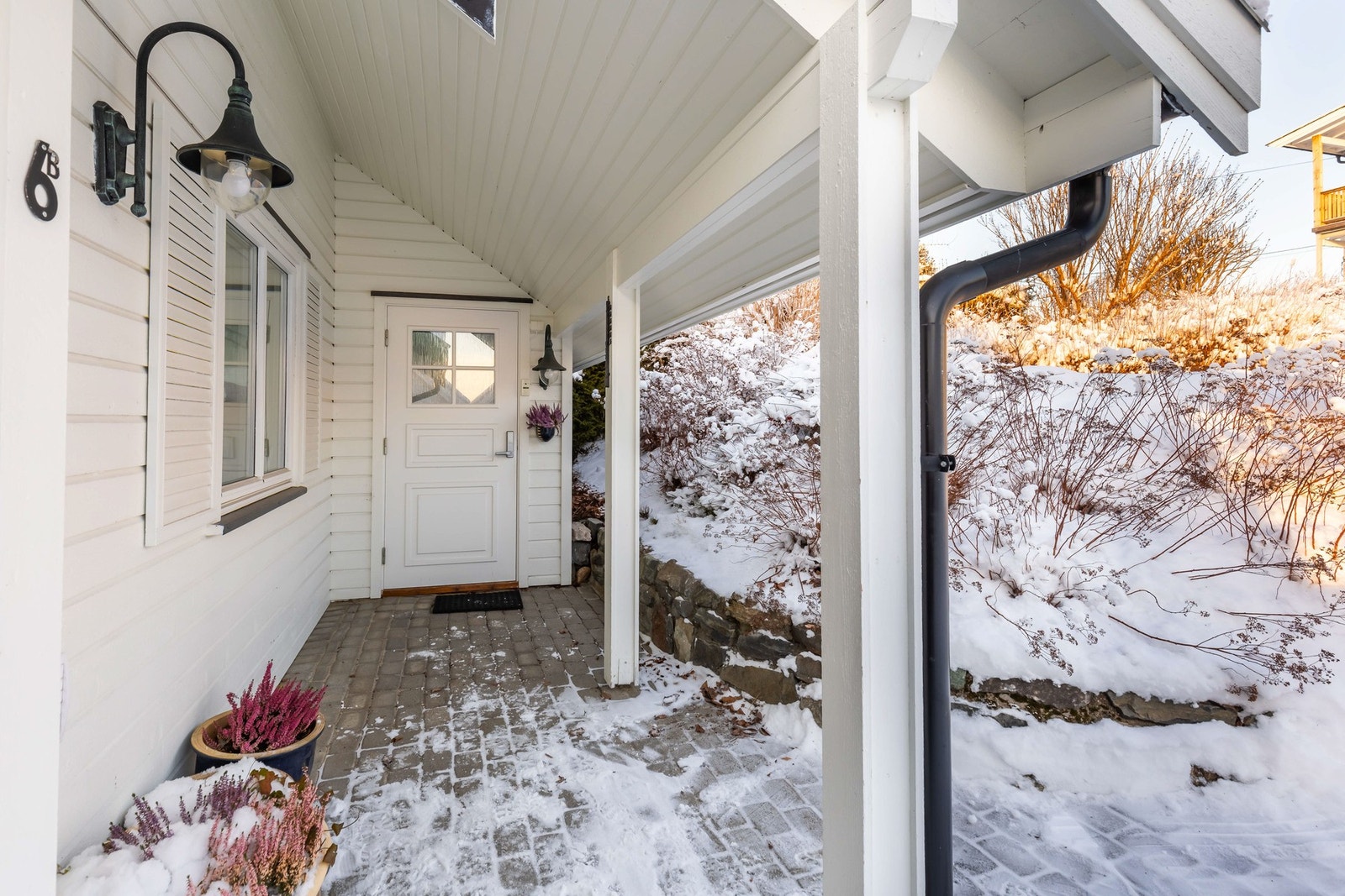 Boligen har et innbydende og overbygd inngangsparti, og både gårdsplass og adkomst er pent belagt med belegningsstein. Galleribilde