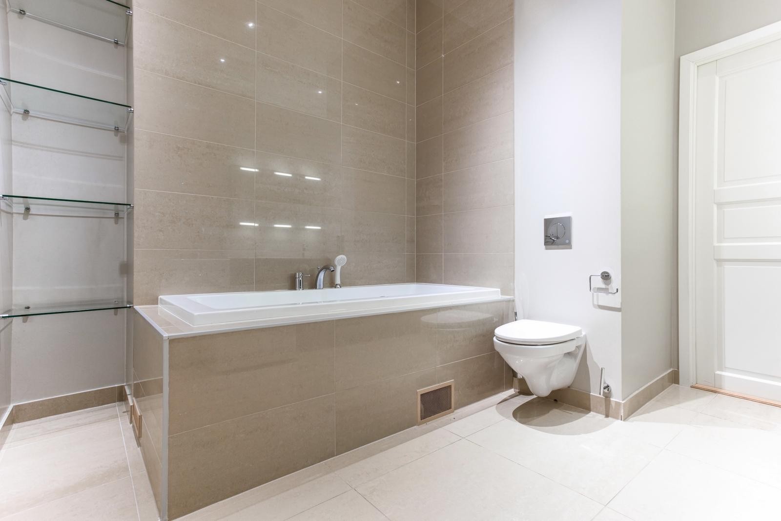 Pent og delikat flislagt bad med badekar. Galleribilde