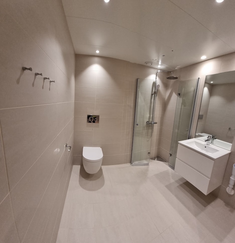 Romslig baderom med spotter, vegghengt toalett, servant og dusj med rainshower! VK i gulv Galleribilde