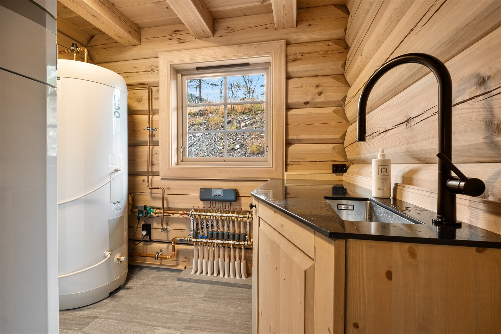 Et praktisk teknisk rom + vaskerom. Her finner du bereder og stoppekran. Varmepumpe - vannbåren varme tilknyttet bergvarme. En praktisk benk og Servant + opplegg for vaskemaskin. Galleribilde