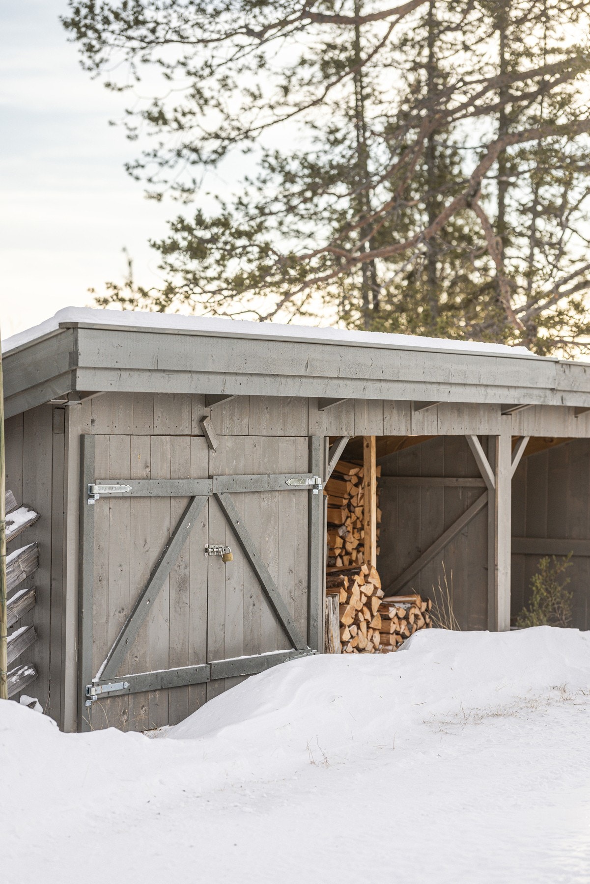 Fjelltunet er opparbeidet med praktiske og funksjonelle løsninger. Her vedskjul med oppbevaring for snøfres og andre viktige redskaper. Galleribilde