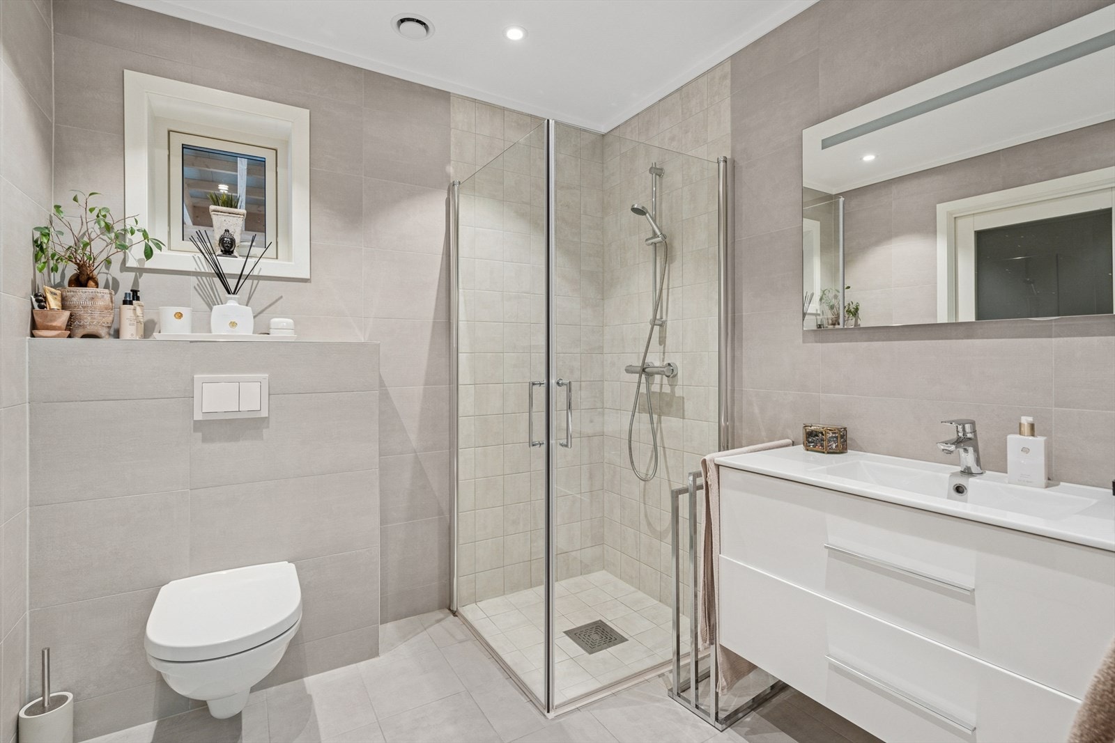 Baderommet er utstyrt med baderomsinnredning med servant, toalett og dusjhjørne. Ventilering via via balansert ventilasjon (avtrekksventil i tak samt luftespalte i dør). Galleribilde