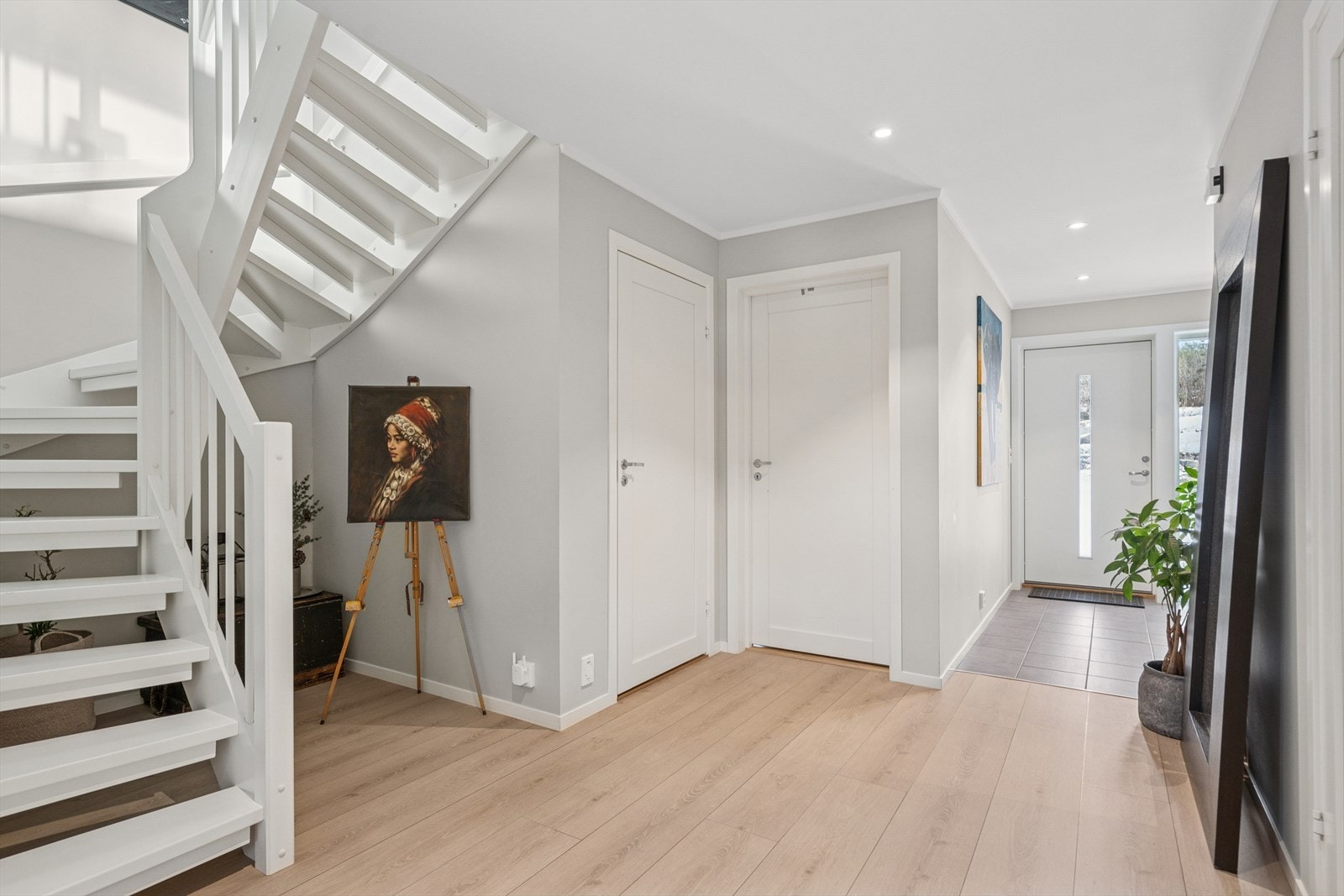 Det er adkomst til boligen fra bakkeplan, og inn i første etasje. Velkommen inn - her ønskes du velkommen inn i lys entrè med plass til å henge fra deg ytterklær. Galleribilde