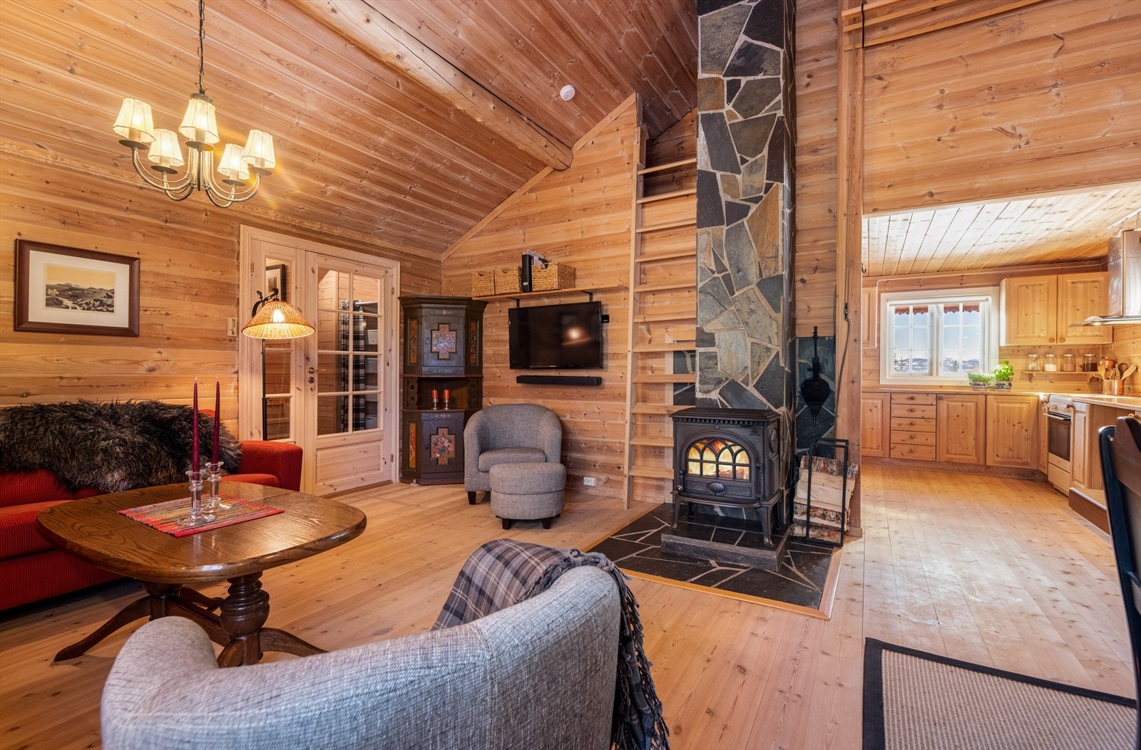 Her er det fint heltregulv som er gjennomgående videre til den åpen kjøkkenløsningen, samt panel på vegger og i himlinger. Rommet gir god plass til møblering av både spisestue, sofagruppe og annet. Galleribilde