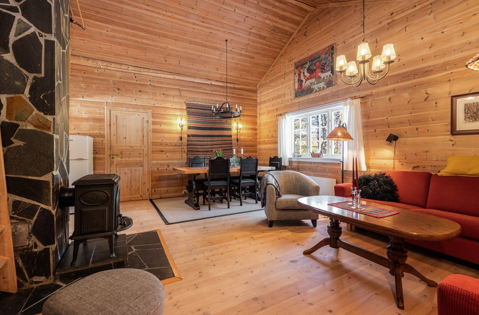 Hytta har en stor og koselig stue med god takhøyde som øker romfølelsen ytterligere. Sentralt i rommet er det en vedovn som gir god varme på kalde dager og et lunt preg. Galleribilde