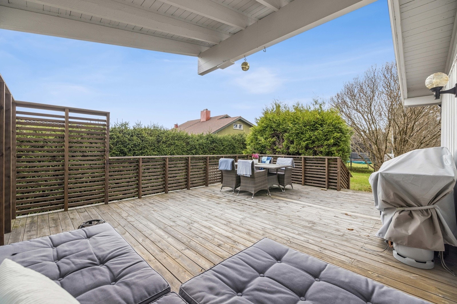 Her er det en skjermet utedel rett utenfor stuen med tak over deler av terrasse og levegger, samt blomsterkasser Galleribilde