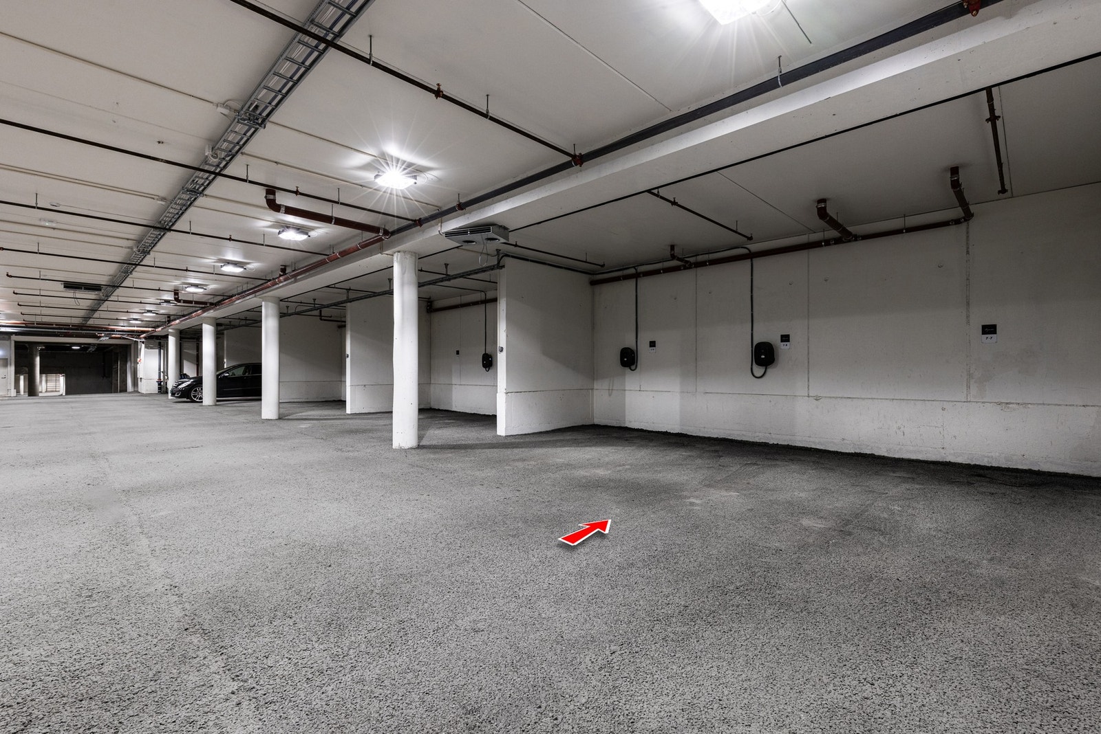 Parkeringsplass i garasjeanlegg med elbil-lader. Galleribilde