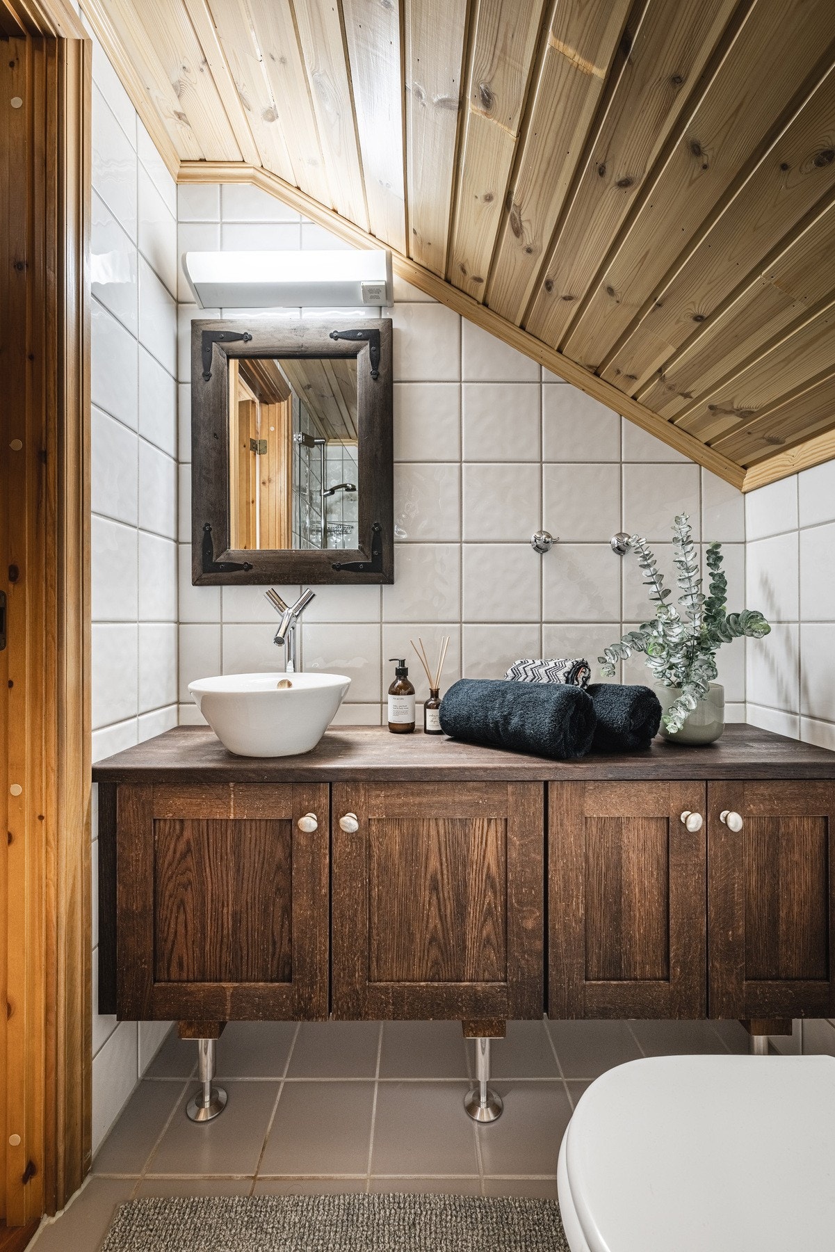 Innredning i mørkt tre gir god balanse i baderommet. Galleribilde