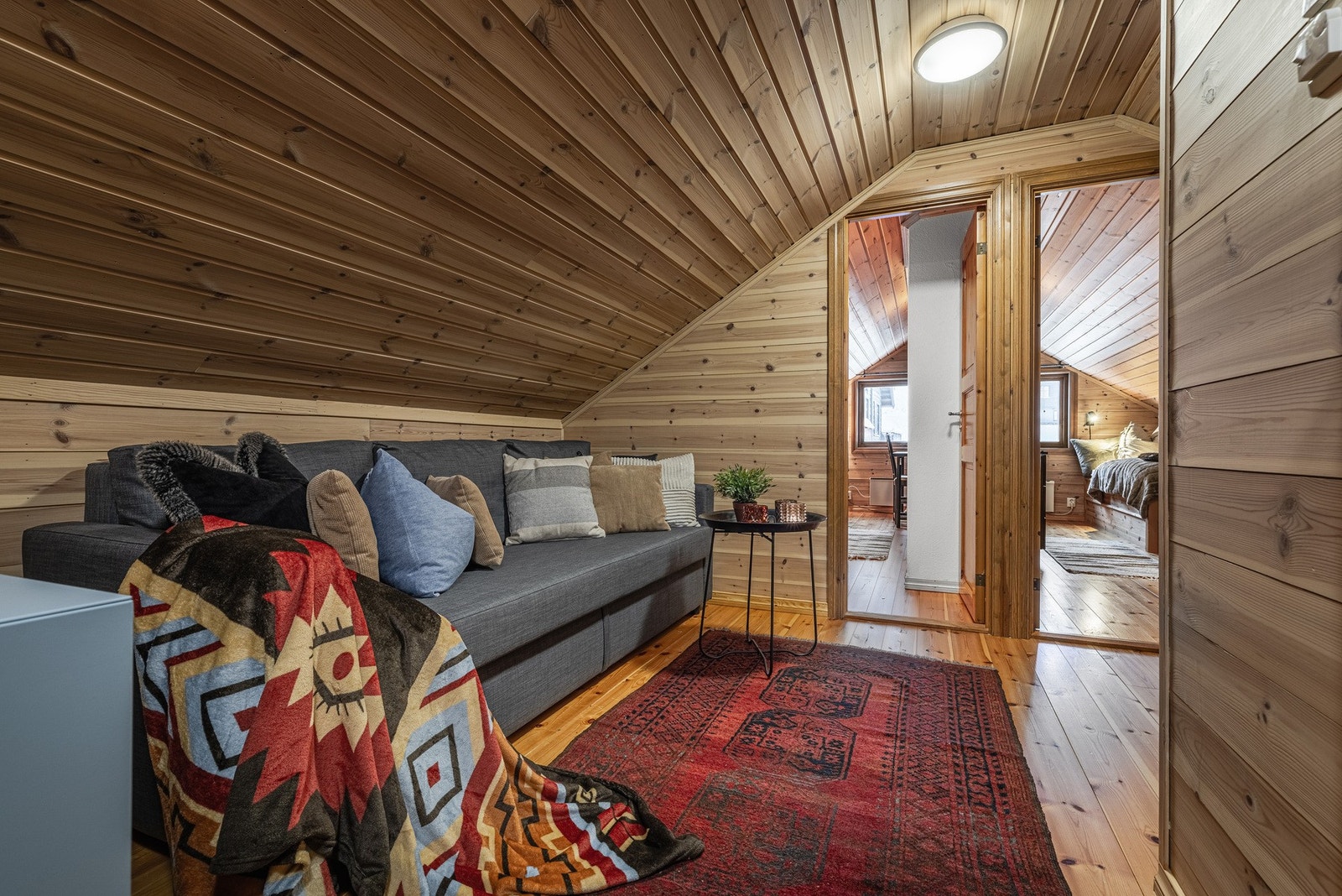 Koselig loftstue med varme trepaneler og skråtak, perfekt for avslapning og hygge. Galleribilde