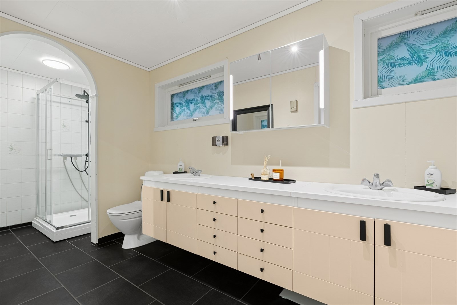 Badet i første etasje har fliser på gulvet. Vegger og himling har malte plater, mens dusjnisjen er flislagt. Galleribilde