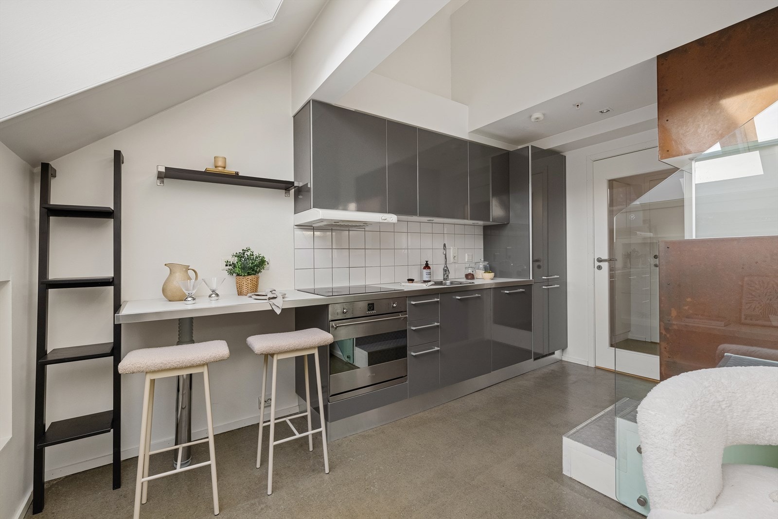 Pent kjøkken utført med grå fronter og integrete hvitevarer. Galleribilde