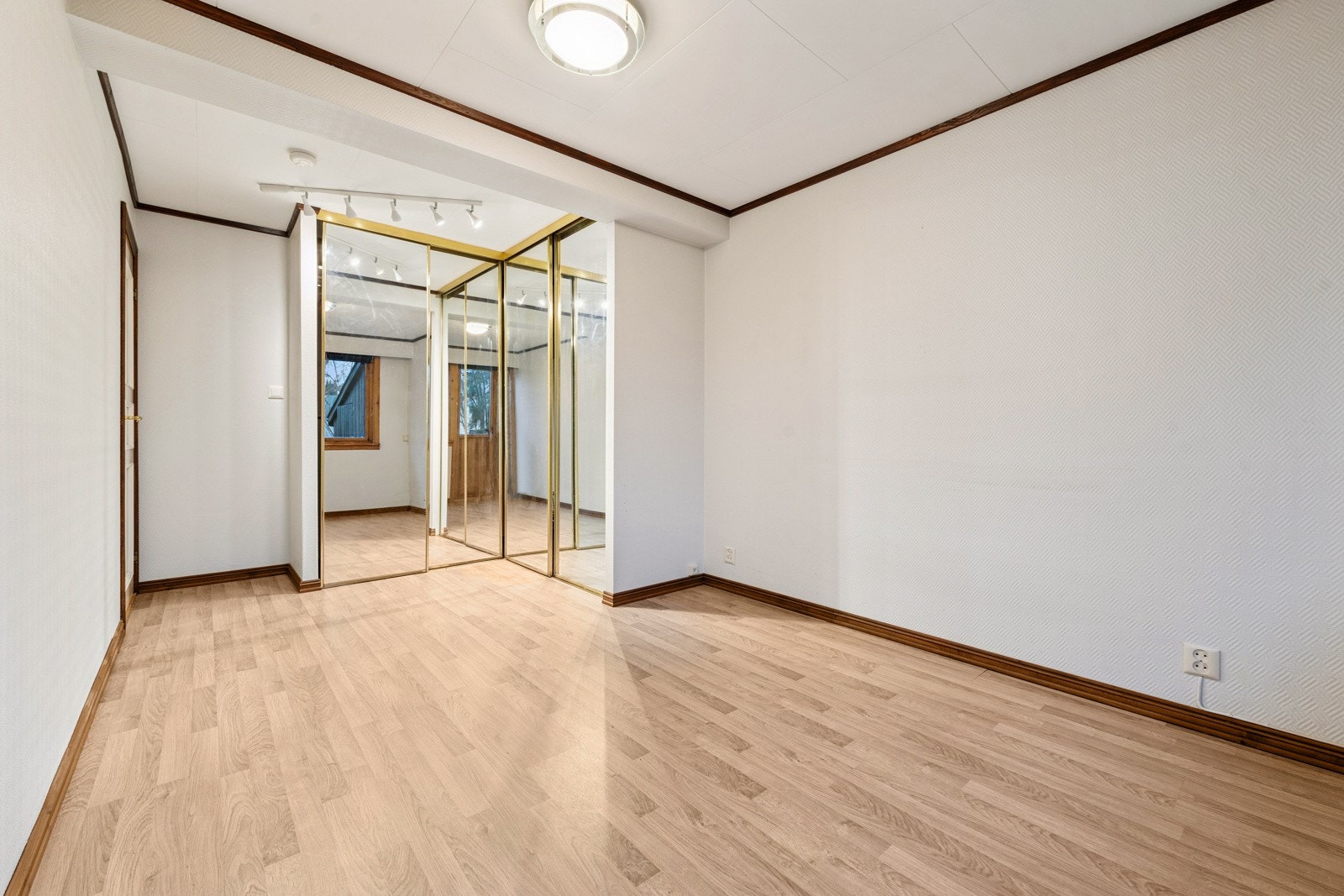 Soverom med laminat på gulv og lysmalte vegger. Galleribilde