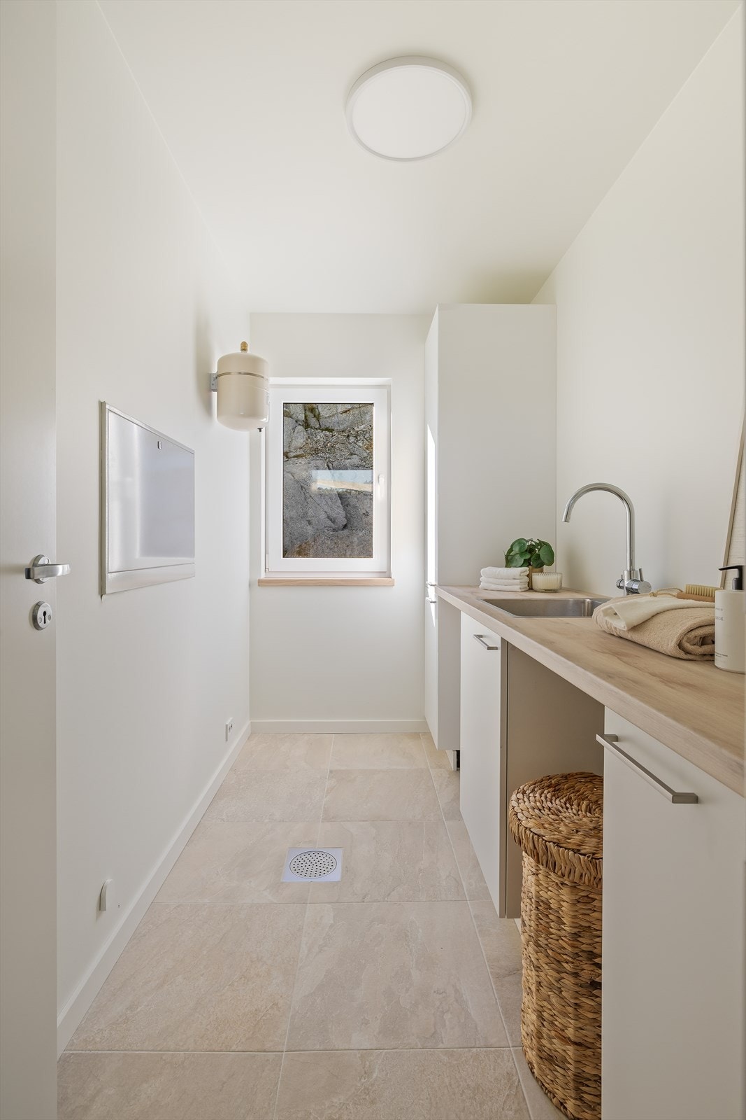 Praktisk, separat vaskerom med flislagt gulv og egen innredning med vask. Galleribilde